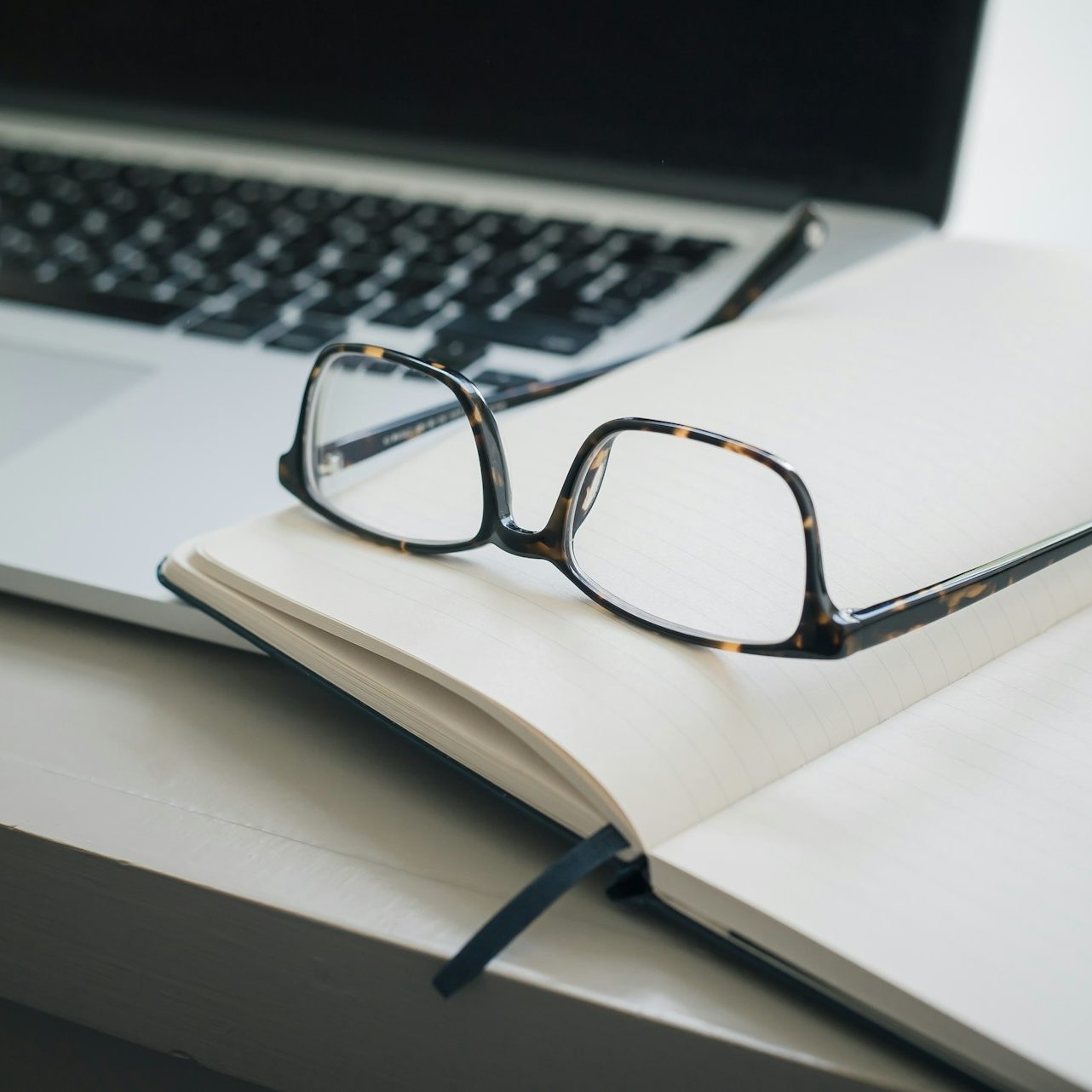 black framed eyeglasses and black pen